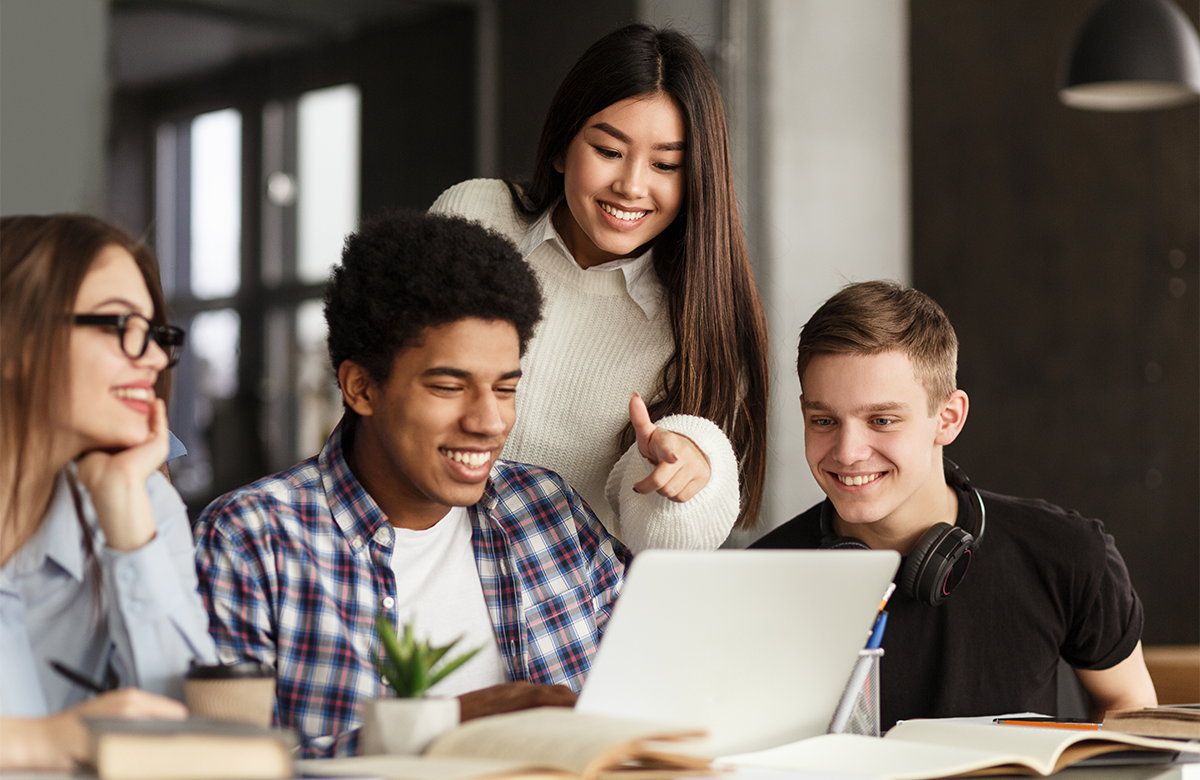 Students in front of a laptop looking at the screen having fun.